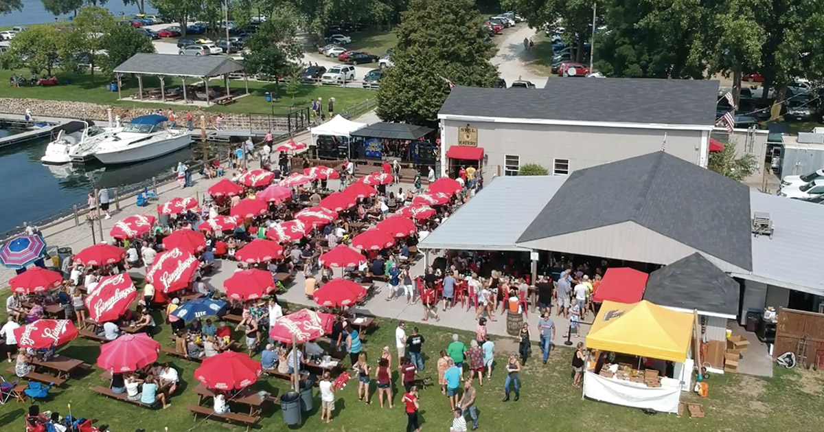 outdoor patio with people and red umbrellas in Whiskey Island Marina, Ohio
